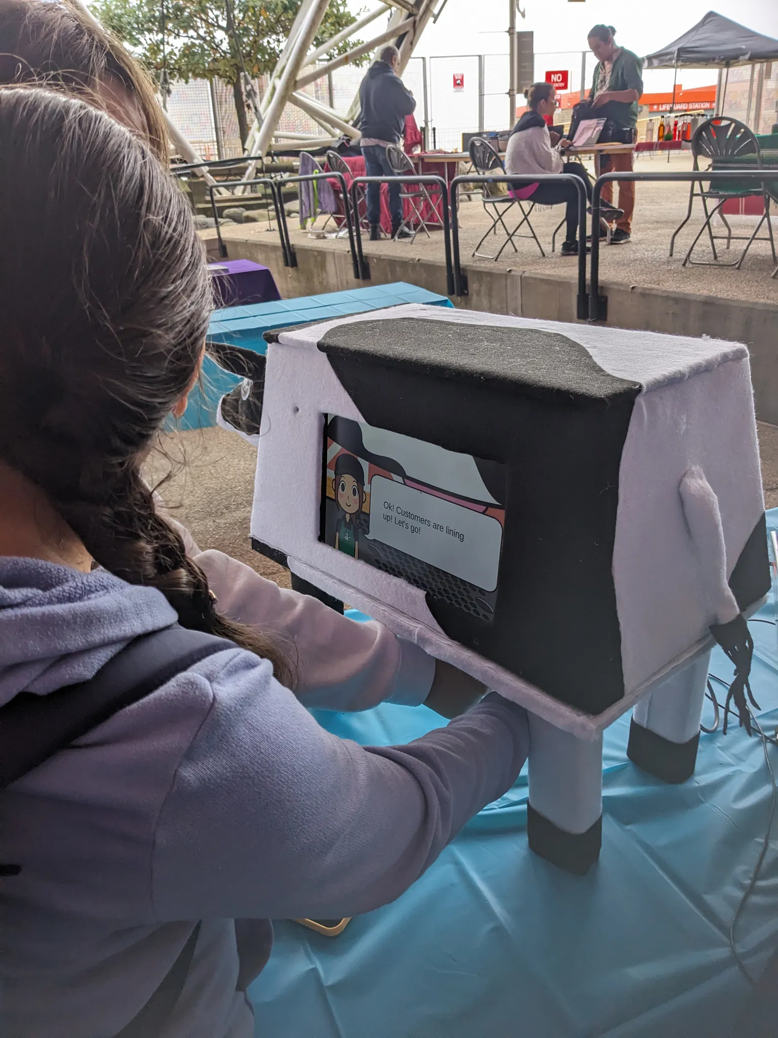 A photograph of a preteen girl going through the tutorial level of Udder Mayhem.