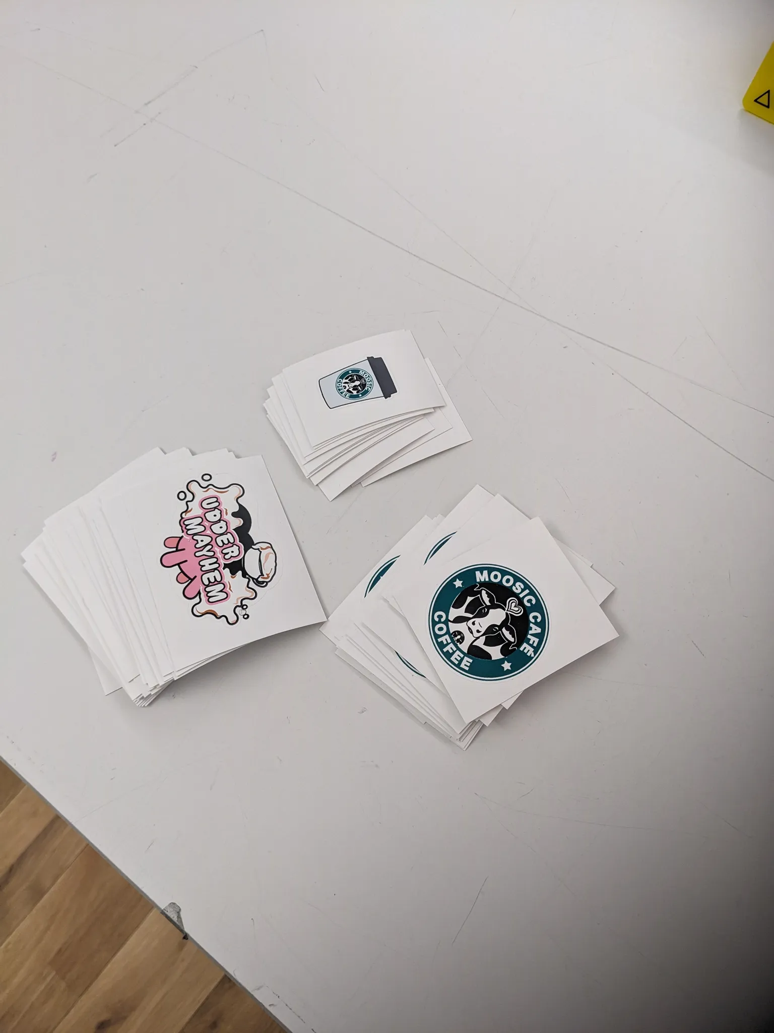 A photograph of a bunch of stickers ranging from a barista character, an udder, and a Starbucks cup