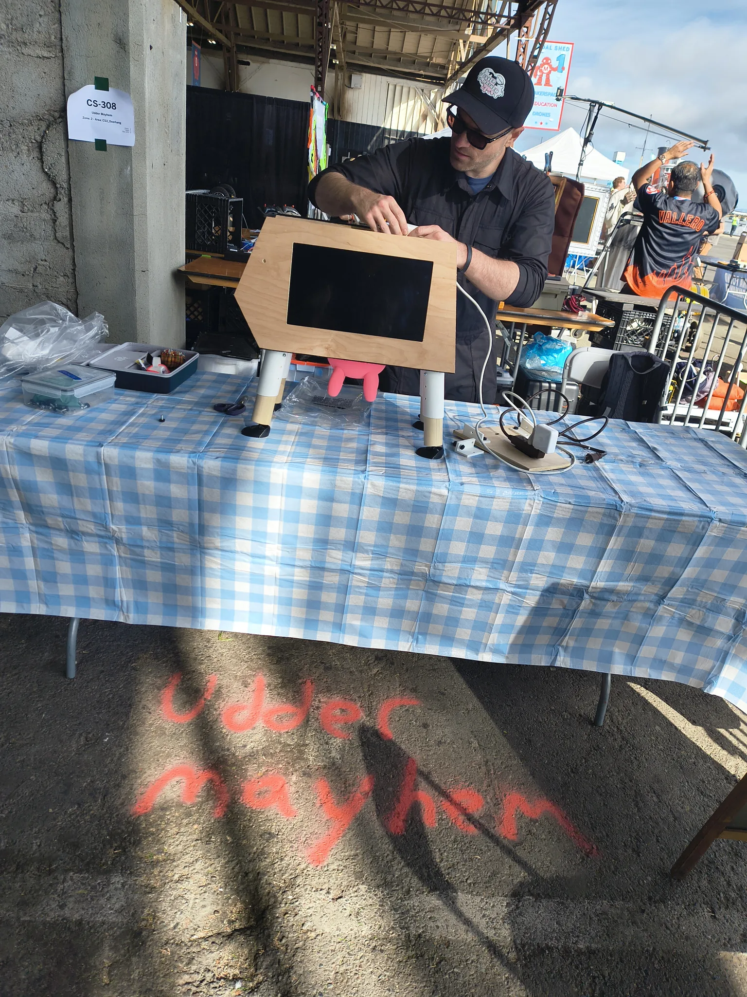 Photograph of Mooriah Dairy being set up on the table, with Udder Mayhem chalked on the concrete below