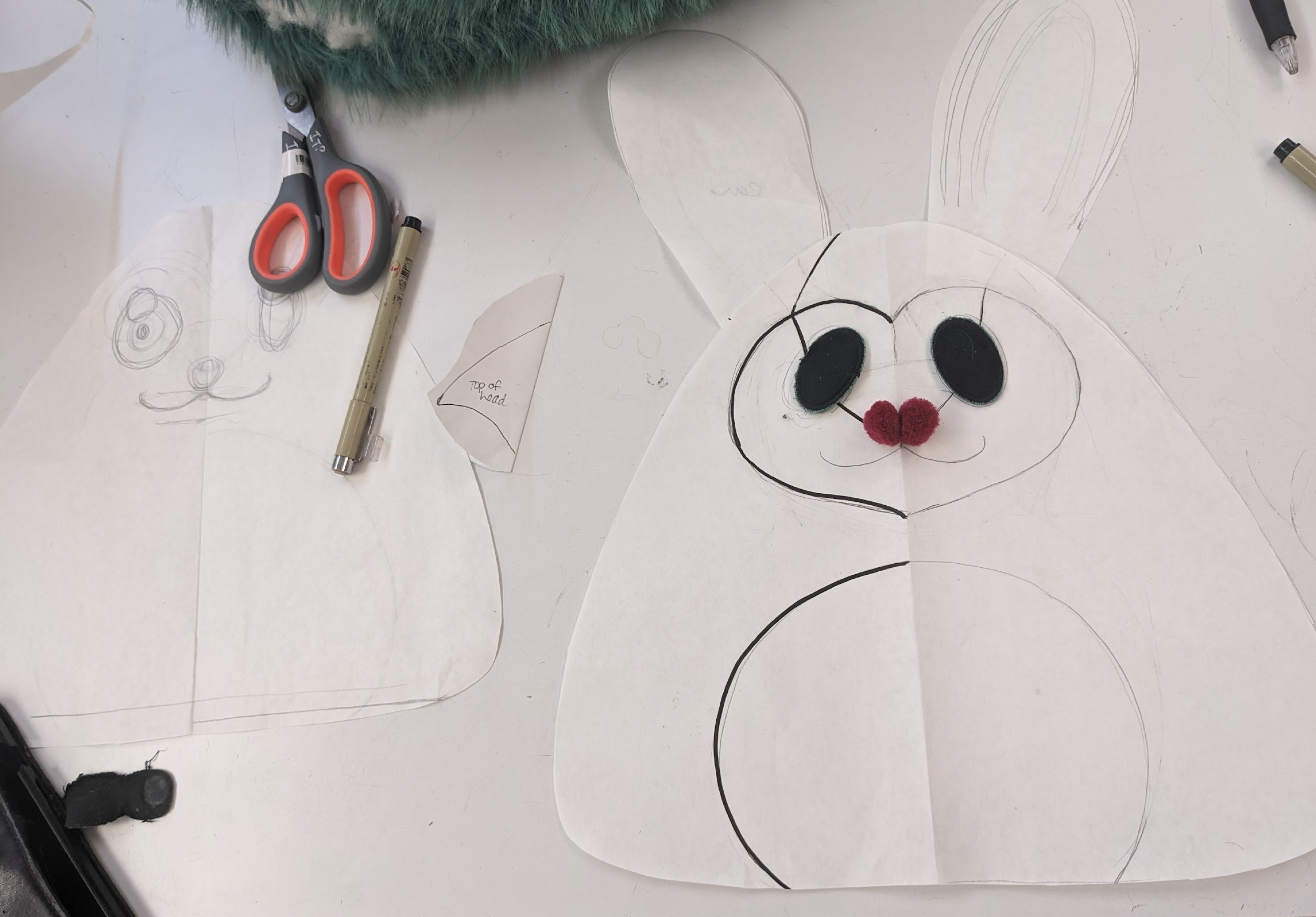 Photograph of a pattern of a character with large ears and no arms cut out of paper