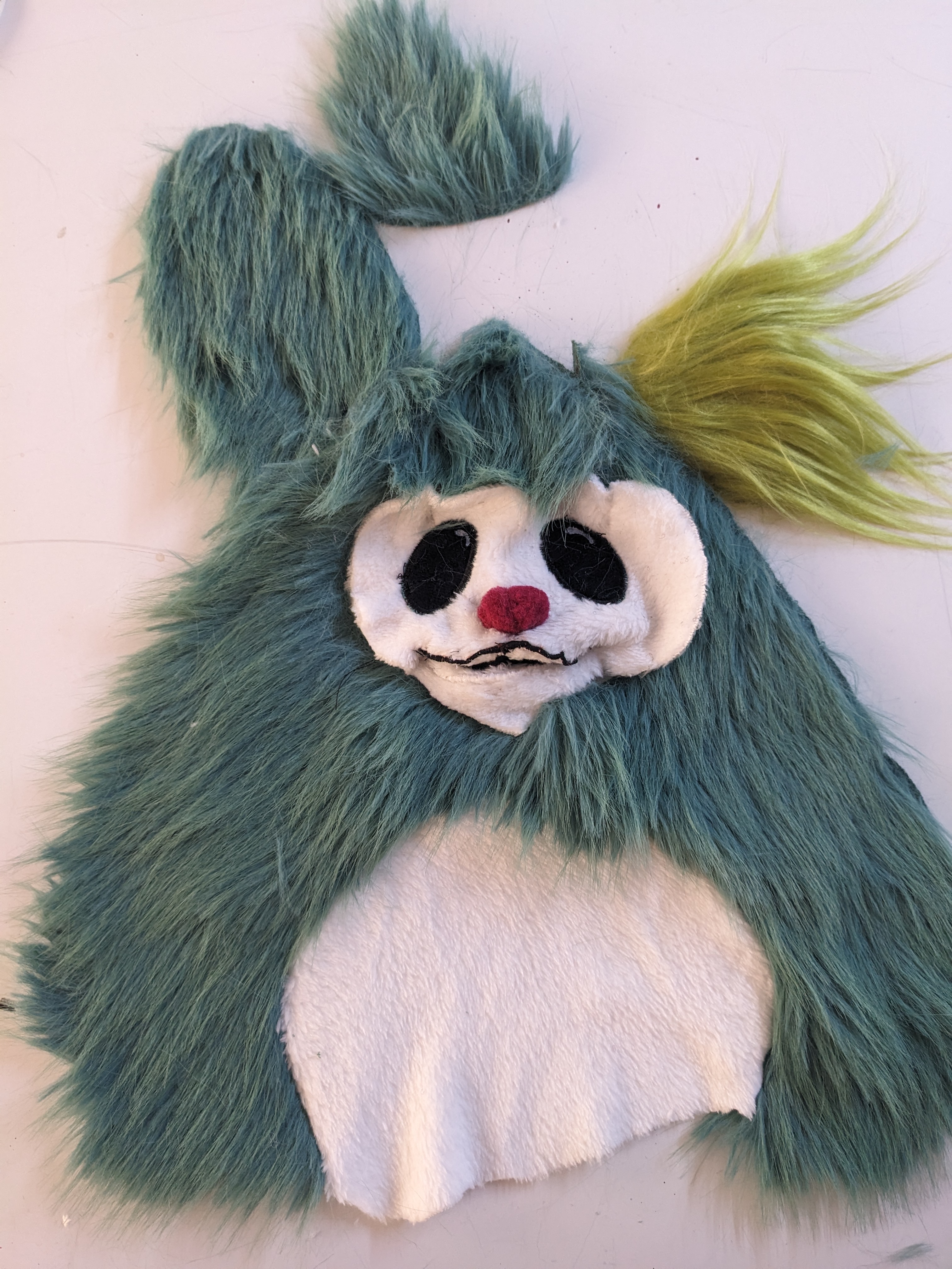 Photograph of a character cut out of fur with several ear options above it