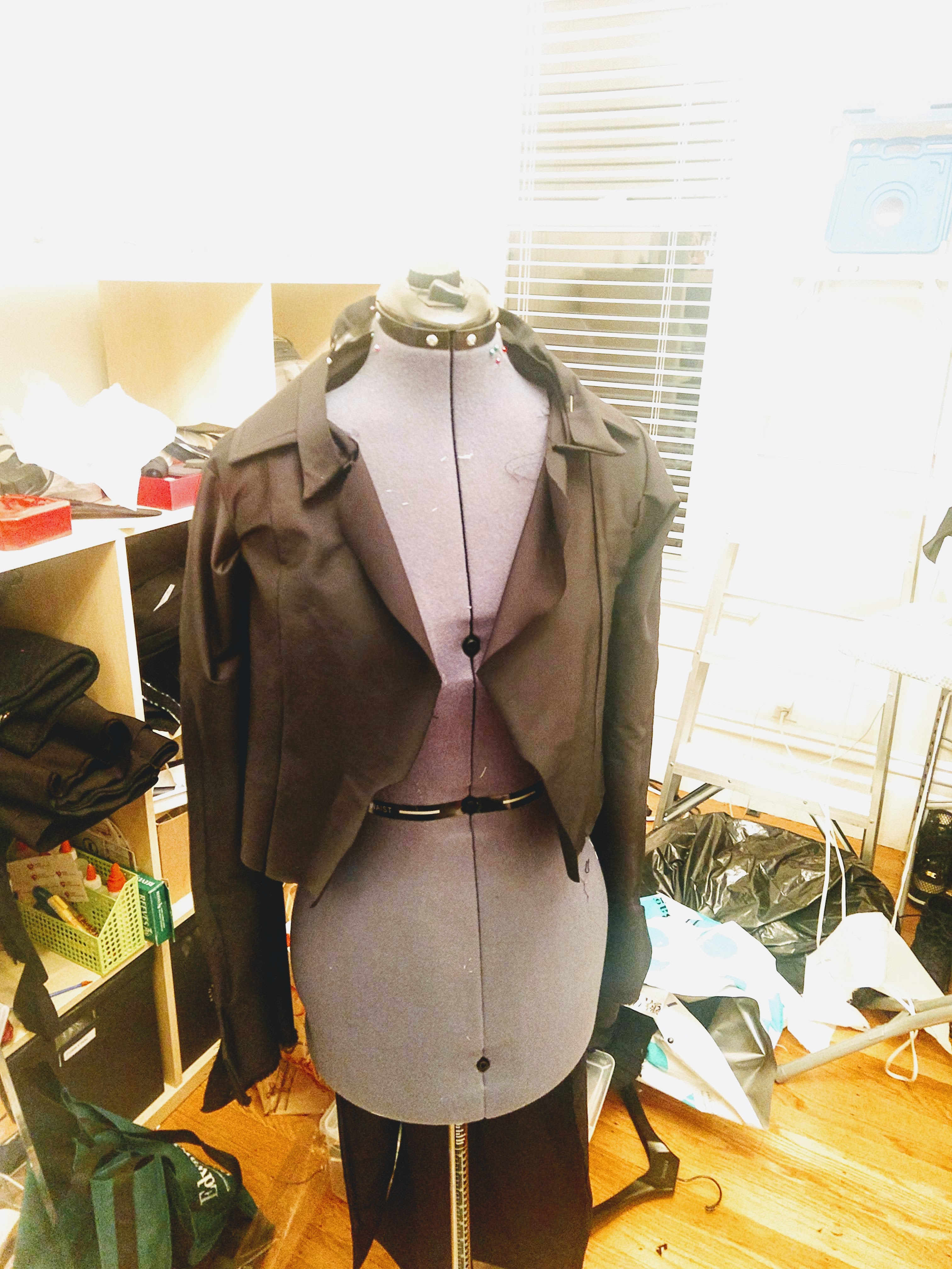 Photograph of a mannequin from the front wearing a black jacket without detailing