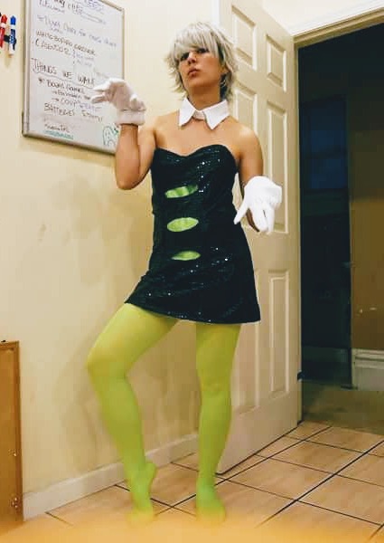 Photograph of a girl in a black and green dress with white gloves and a white wig posing for the camera