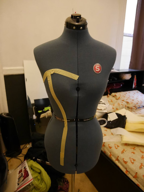 Photograph of a blue mannequin with tape outlining a heart top