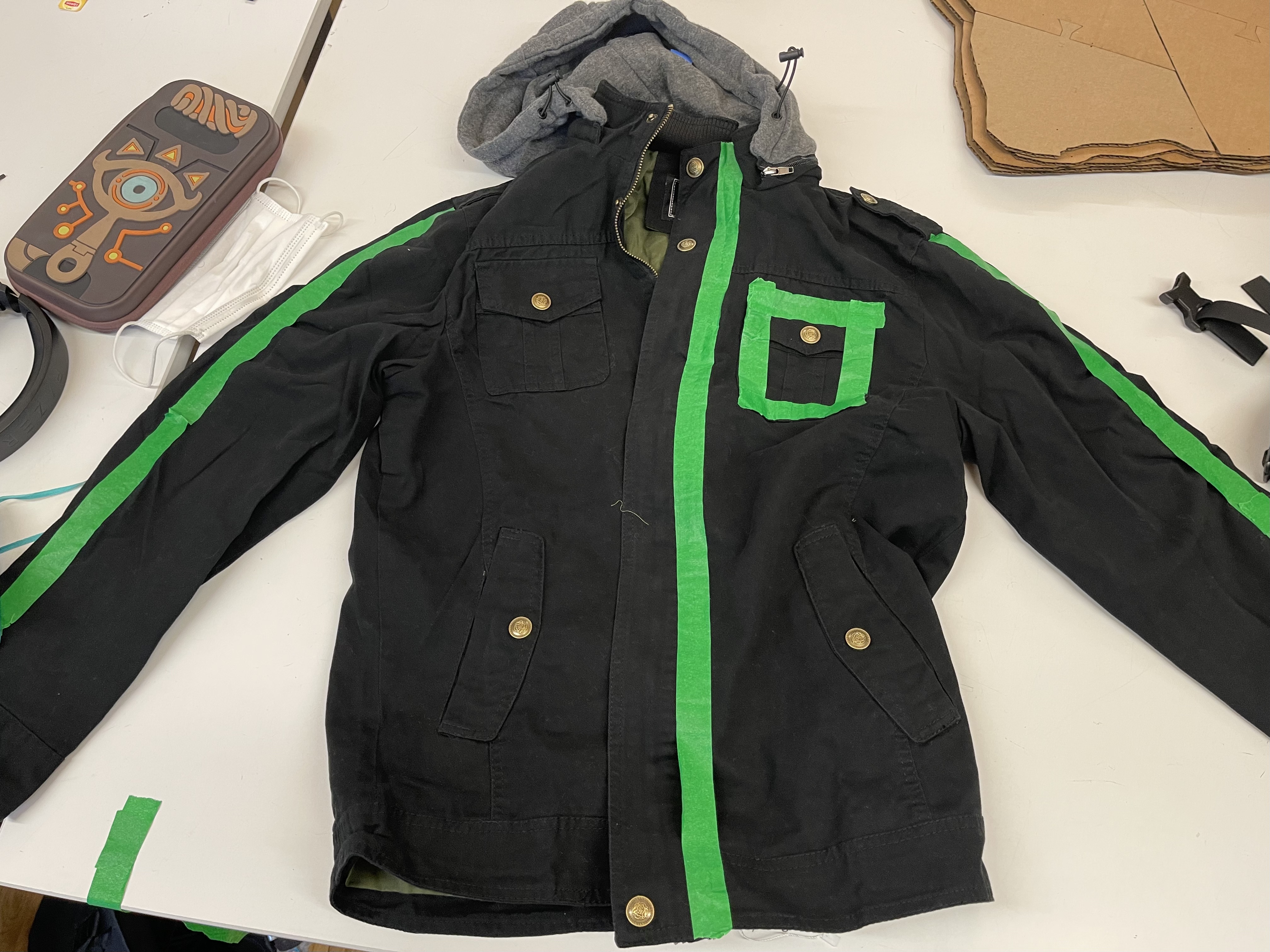 Photograph of the jacket covered with green tape marking where lights will go down the front