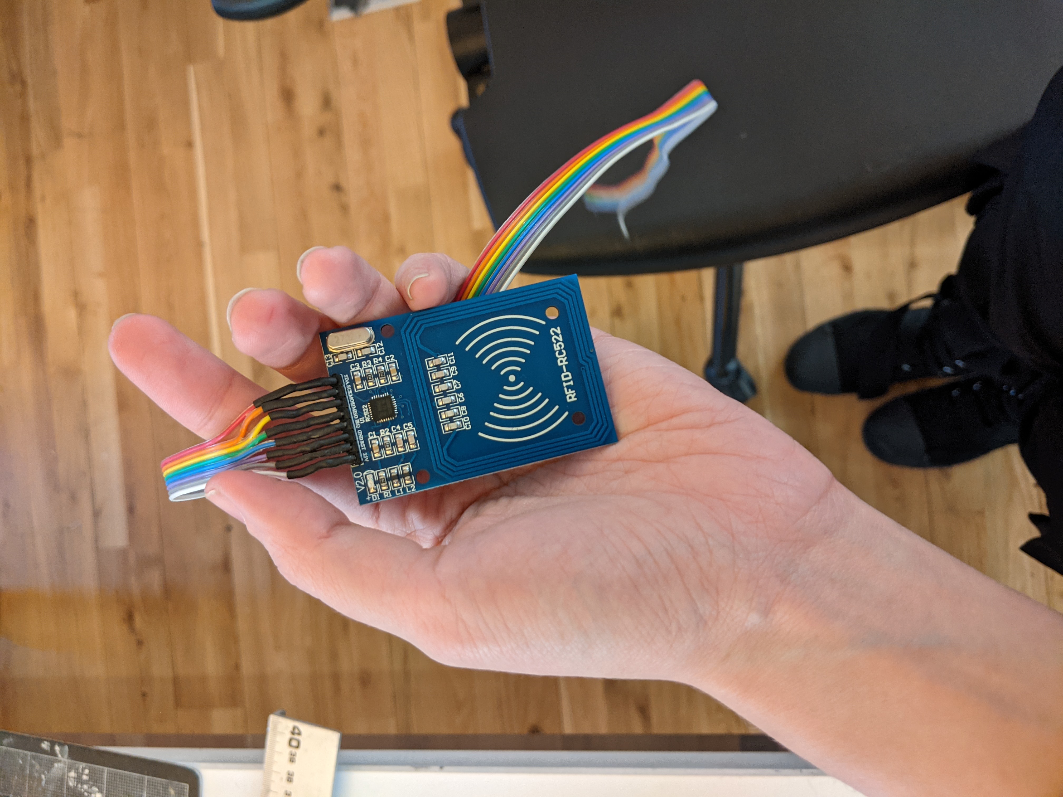 Photograph of a small RFID reader with a ribbon of wires soldered on