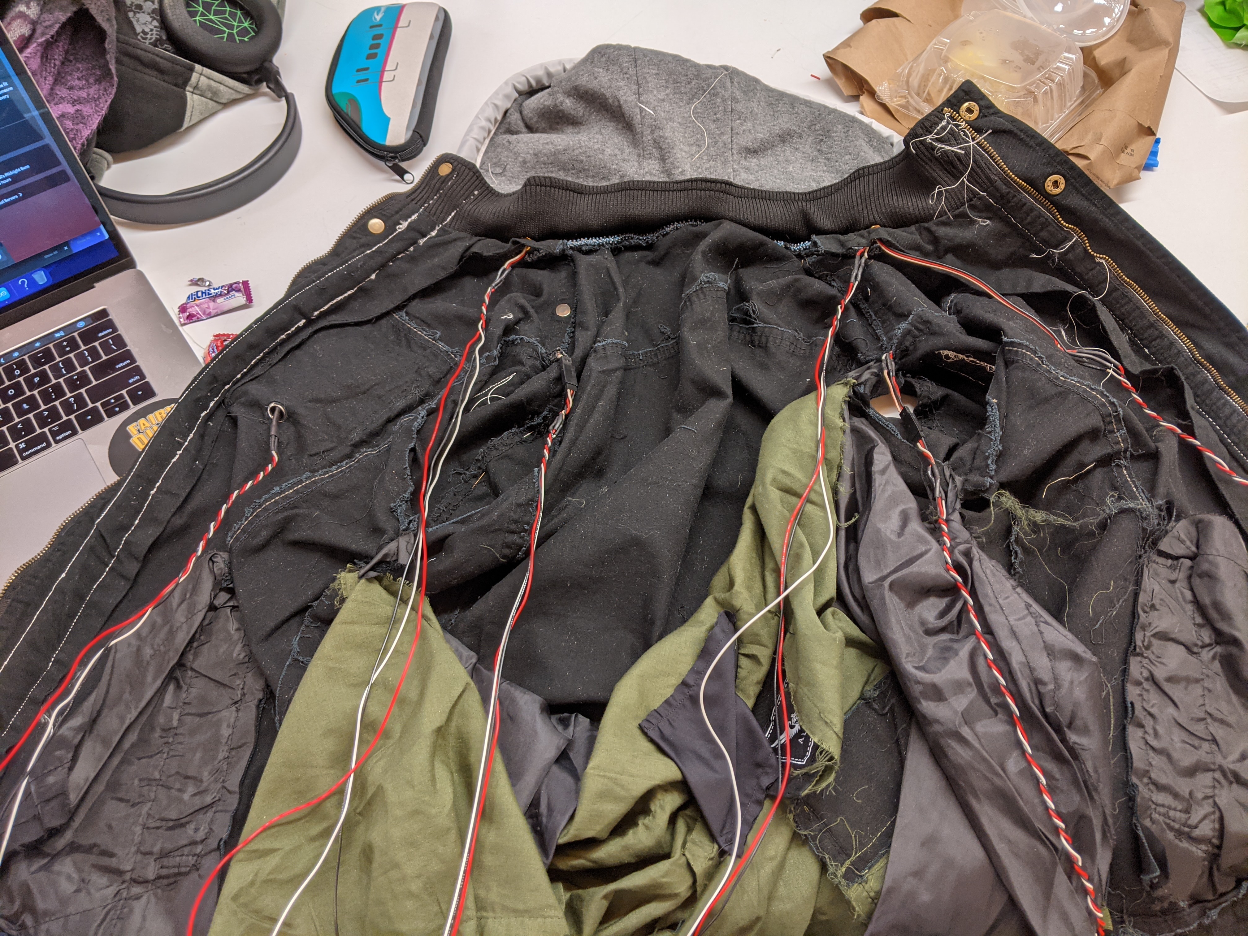 Photograph of the jacket with the lining seam ripped out and cables all over the back