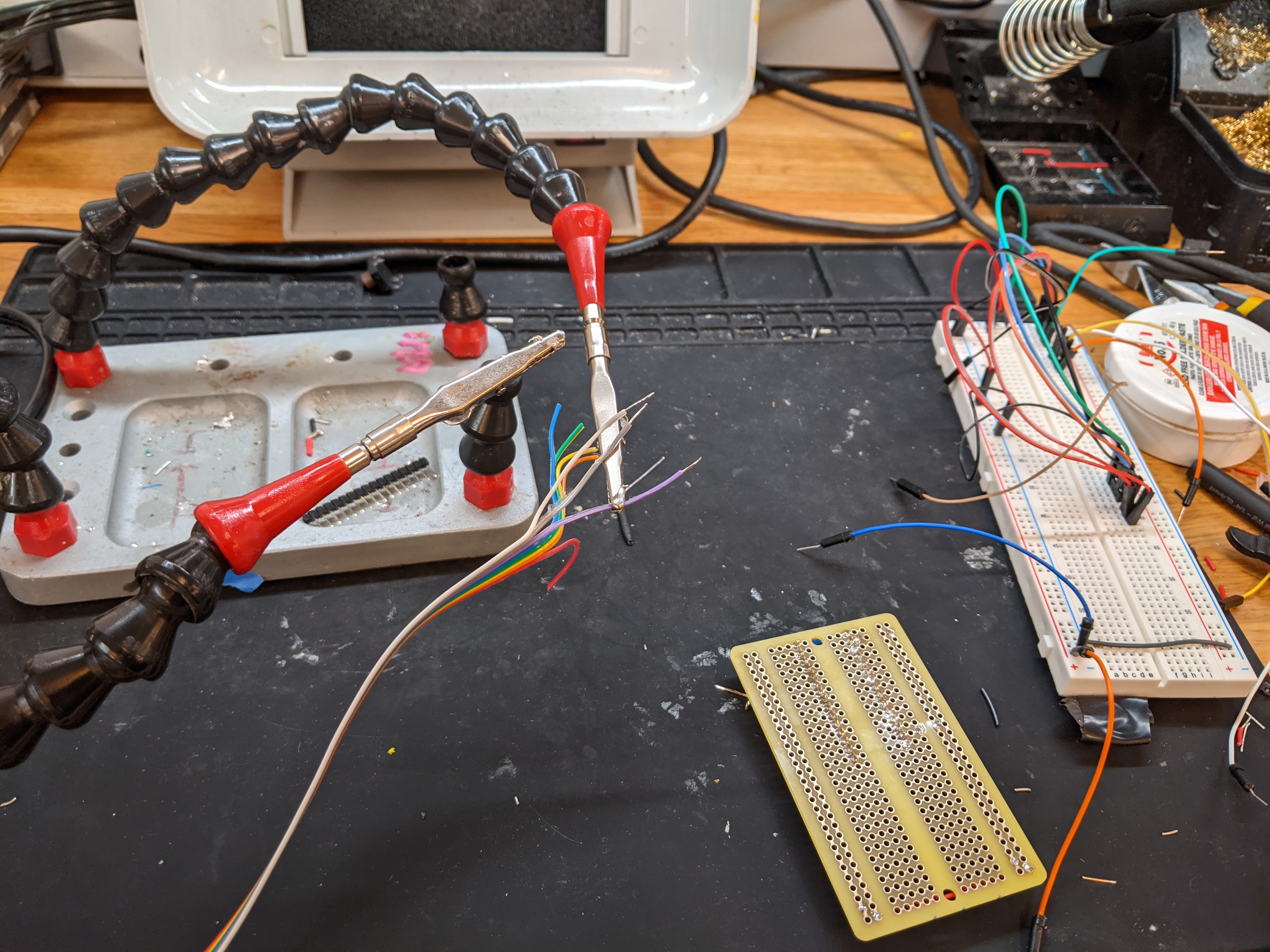 Photograph of a ribbon of wires sitting on helping hands, ready to be soldered