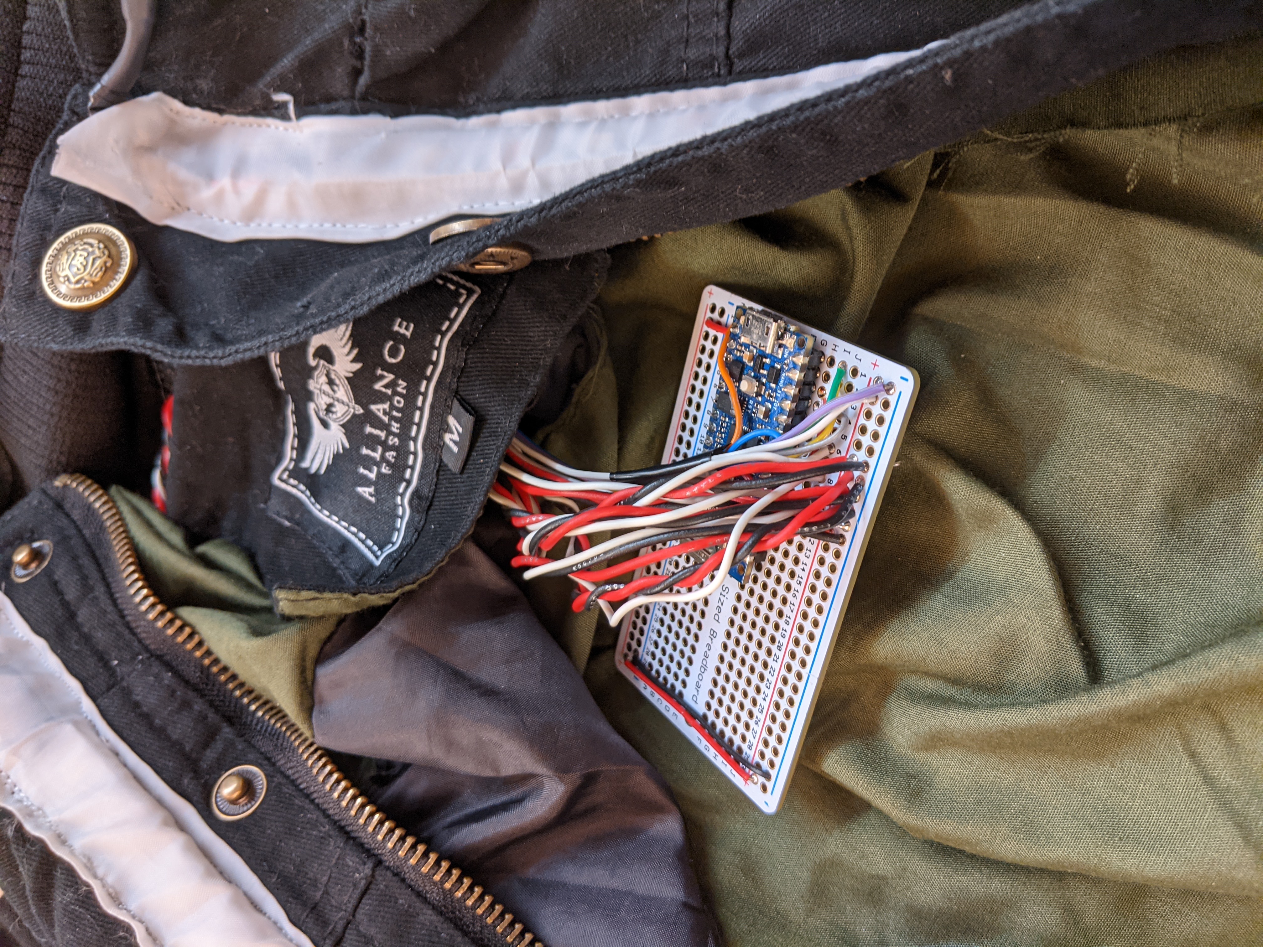 Photograph of a protoboard with tons of red and black wires coming from it