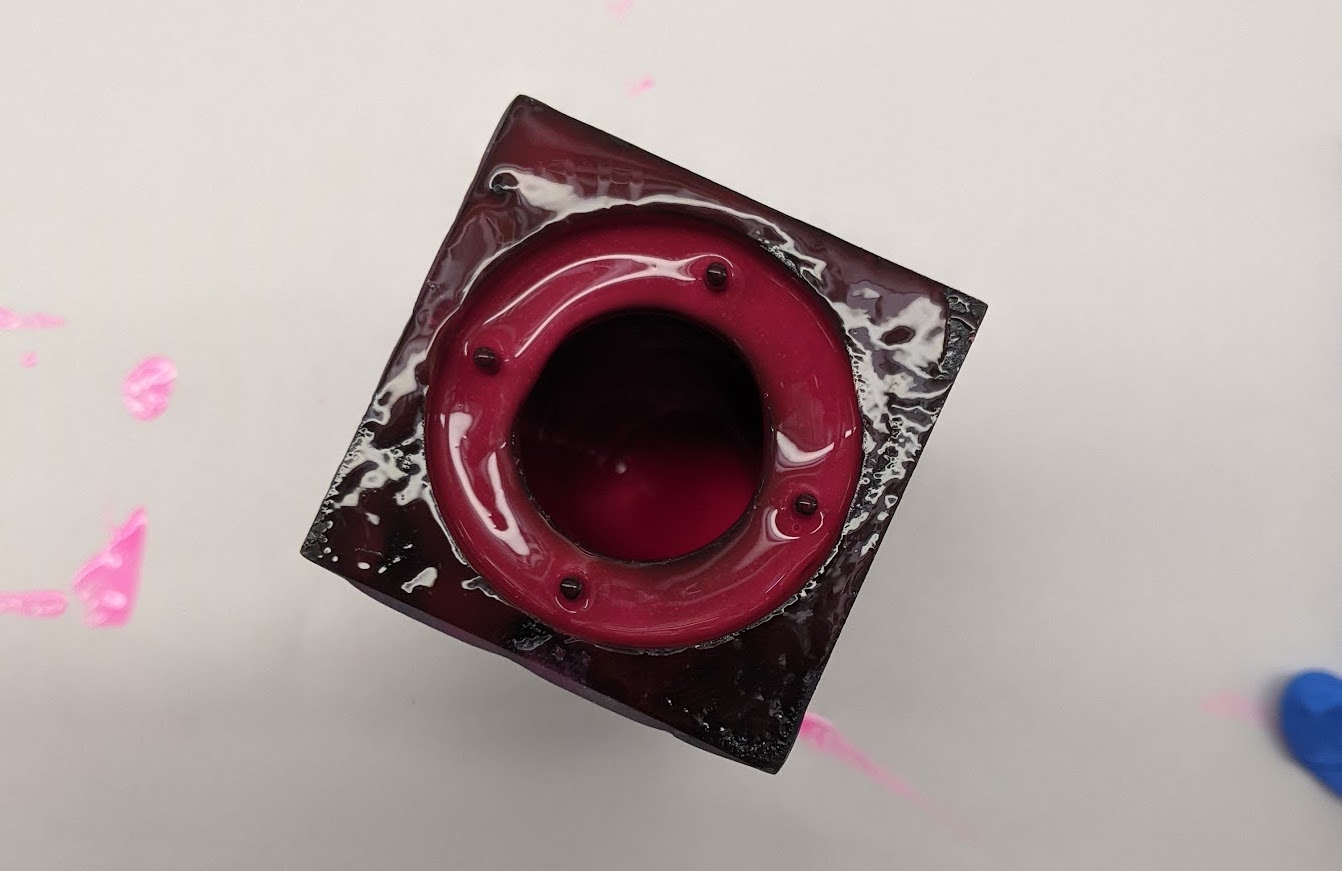 Photograph of a very grotesque looking black box with pink goo in it