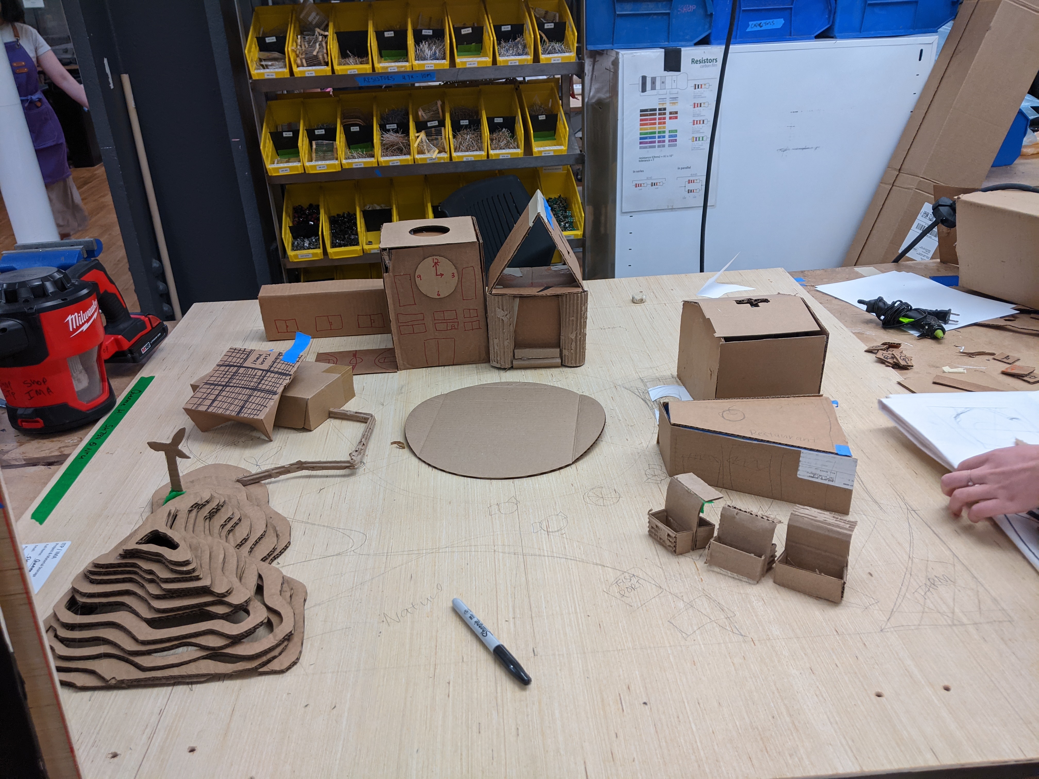 Photograph of a bunch of small buildings made of cardboard laid out in a circle